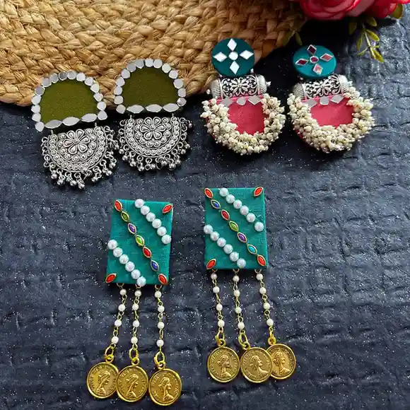 A collection of three pairs of handcrafted earrings: olive-green mirror chandbalis, pink and teal pearl-beaded hangings, and teal rectangular coin danglers.