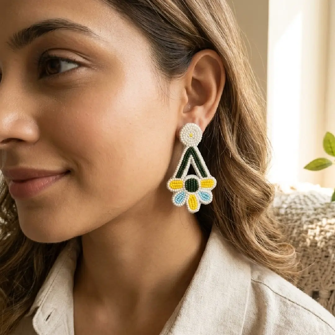 Lifestyle shot of a model wearing handcrafted white, yellow, and blue floral seed bead earrings from Itsy Bitzy Kolkata, styled with a pastel cotton kurti in a sunlit setting.