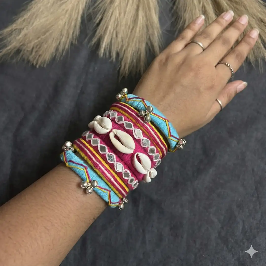 Close-up of handcrafted ethnic bangles worn on a hand, showcasing the detailed mirror work and silver ghungroo bells.