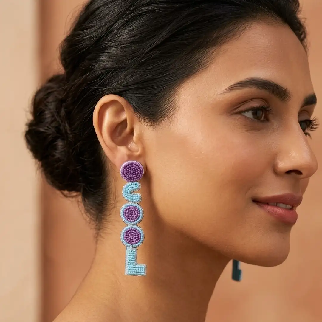 A model wearing long, handcrafted beaded statement earrings that spell