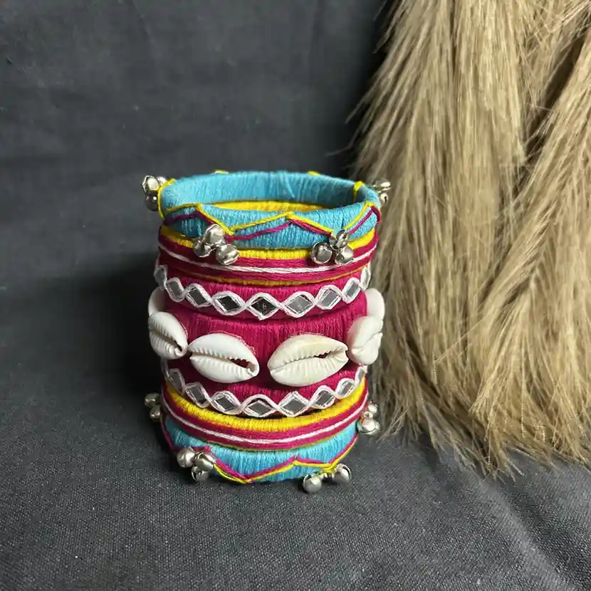Handcrafted multi-color silk thread bangles with white cowrie shells, mirror work embroidery, and silver bells.