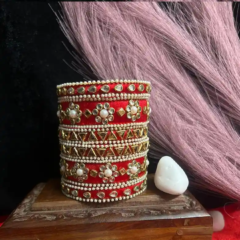 Handcrafted Rajwadi bridal bangle set in red silk thread featuring intricate Kundan floral patterns and pearl-beaded borders.