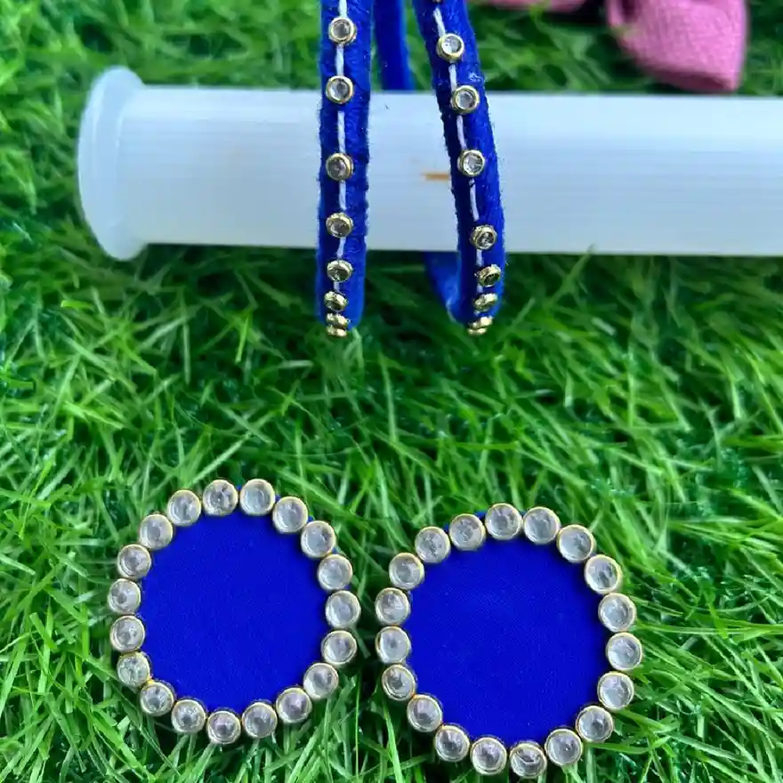 Handcrafted royal blue silk thread jewelry set featuring two bangles with gold stone accents and matching circular stud earrings with a white stone border.