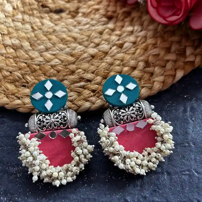 Handcrafted teal and pink fabric earrings featuring mirror work and thick white pearl clusters.