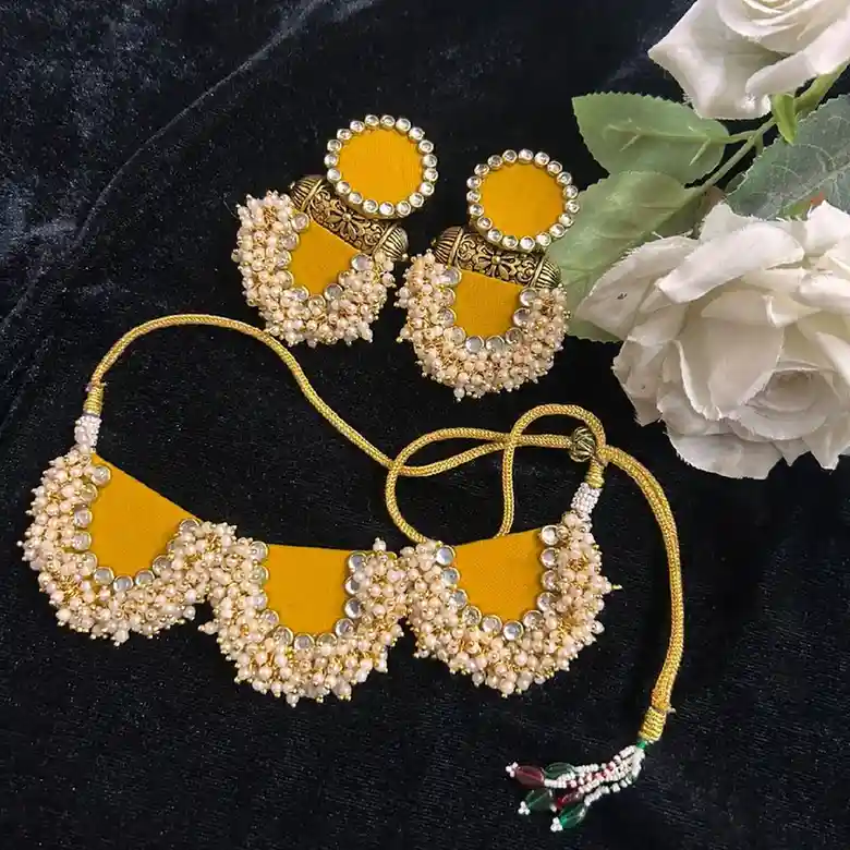 Handcrafted yellow fabric choker and earring set by Itsy Bitzy Kolkata, featuring intricate kundan work and dense pearl bead clusters for Haldi ceremonies.