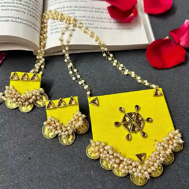 Handcrafted yellow fabric long necklace and earring set from Itsy Bitzy Kolkata featuring a rectangular pendant with gold coins, white seed pearls, and triangle mirror work on a jute background.