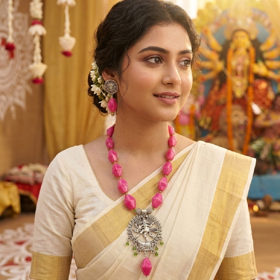 A model wearing a sleek, small-sized pink beaded Nataraja oxidized necklace set from Itsy Bitsy Kolkata with a traditional cream and gold saree during Durga Puja morning